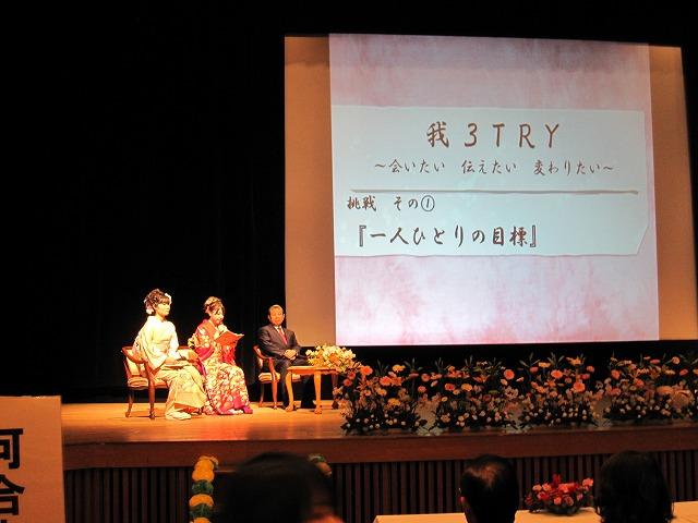 桜色の背景に「3TRY」と表示されたスクリーンバックに市長を交えたセレモニー&インタビューを進める新成人達の写真