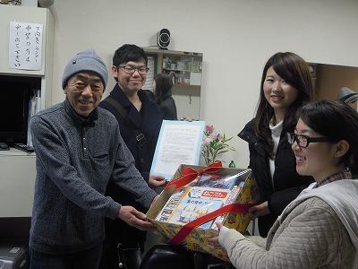 あつまった本を届ける実行委員の女性2人と受け取っている男性2人の写真