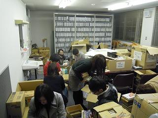 室内でダンボールに囲まれて作業する実行委員達の写真
