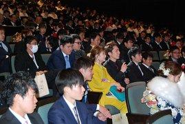 新成人達が席に座って壇上の劇を眺める写真