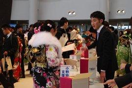 成人式会場にて、会話をする振袖姿の女性と、スーツ姿の男性の写真