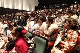 新成人達が席に座ってスクリーンを眺める写真
