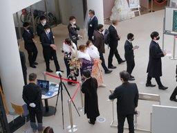 成人式の会場の内部の玄関口に入場する11人の成人の男女の写真
