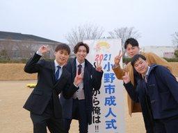 成人式の会場の外にいるスーツの四人の男性の写真