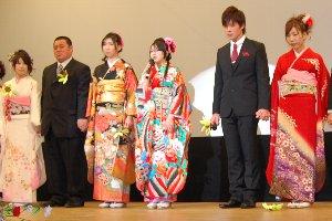 ステージ上にて男女の新成人が一列になって立っている写真