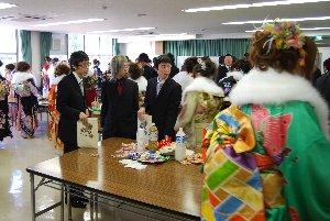 新成人が、懐かしい給食などの軽食を立食している写真