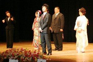 壇上であいさつをする男性の実行委員の写真