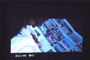 スクリーンにアルバムを開いている映像が写っている写真