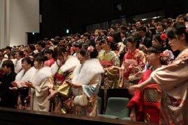 新成人達が席から立ち壇上へと拍手を向ける様子の写真