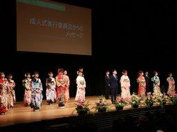 成人式典の終わりに19人の運営委員会の男女が立っている写真