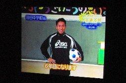 アシックスのウェアを着てサッカーボールを抱えた男性の写真