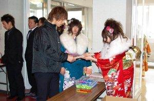 式典に参加する人の受付をする新成人の写真