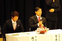 司会の男性とマイクを持ったパネリストの写真