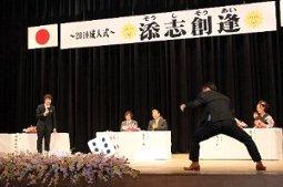 添志創逢〜新成人によるサイコロトーク〜と題して舞台上で大きなサイコロを振る新成人とパネリストの写真