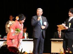 壇上に実行委員二人と市長が立ち式を採り進めている様子の写真