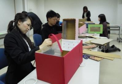 段ボールと色紙で回収ボックスを作る実行委員の写真