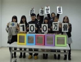 目指せ100万個の文字をそれぞれ持ち、5つの回収ボックスを前に立つ実行委員の写真