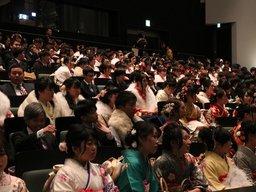 新成人達が席に座ってスクリーンを眺める写真
