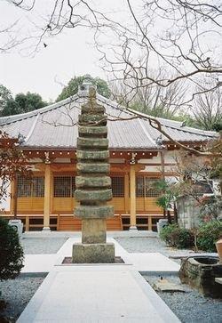 養父寺本堂前に立つ石造層塔の写真