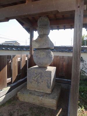 木造の囲いと屋根に守られて建つ慶徳寺石造五輪塔の写真
