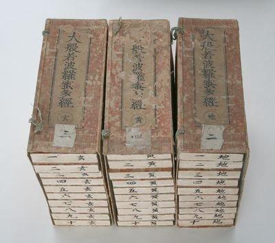 古びた大般若経中野板が10巻ずつ3列に積んで並んでいる写真
