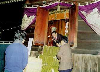 神明神社に参拝し神火をもらい受ける参拝者の写真