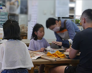 陶芸を教える先生と子ども
