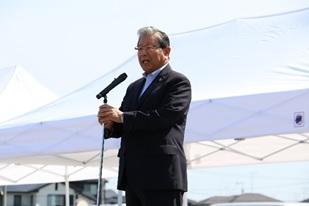マイクを握りながら挨拶をする市長の写真