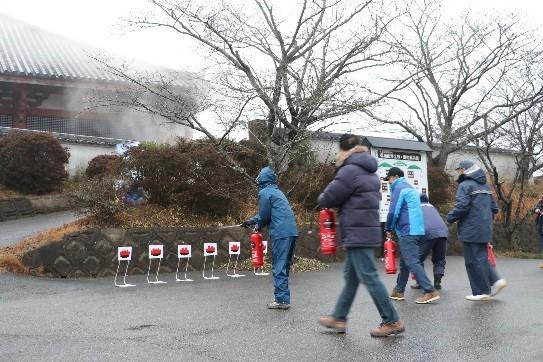地元住民たちが赤い的に向い消化器を使い訓練している写真