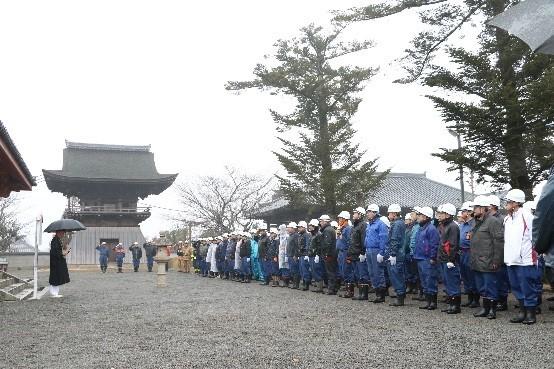 寺院の広場で参加した消防団員たちが並び防火訓練の閉会式を行っている写真
