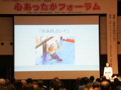 ステージに設置された大型スクリーンの脇で伊藤真波さんが講演を行っている写真