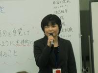 黒のジャケット姿でホワイトボードを背にマイクを持ち笑顔で講義をする様子の菅野美樹さんの写真