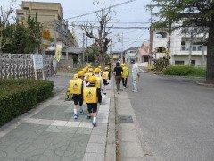 補導員の見守りの中並んで下校する児童たちの写真