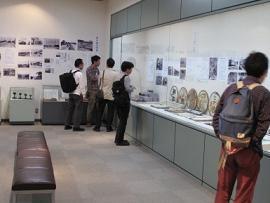 企画展「神戸電鉄の歩み」の展示物を眺めている人たちの写真