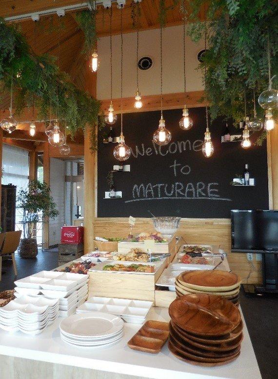 ランプや植物が吊り下げられている店内でビュッフェが開かれているマトゥラーレの写真