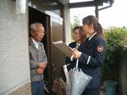 女性消防団員が独居の高齢者世帯を訪問して玄関で指導をしている写真