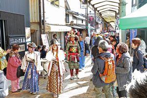 小野商店街の間を鎧などを着ている人々が大名行列をしている写真