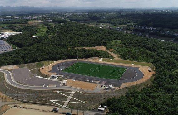 コートに芝生のはられた陸上競技場を空中から俯瞰した写真