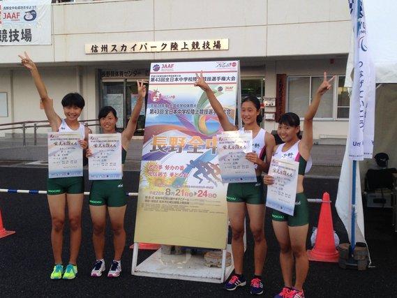 女子中学生4人が全国大会の看板の前でピースをしている写真