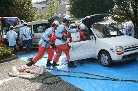 乗用車から負傷者を運び出そうとしている救急救助訓練の写真