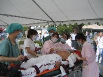 テントの下で負傷者の対応をしている看護師の人たちの写真