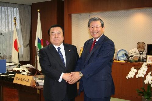 冬柴国土交通大臣と市長が握手をして正面を向いている写真