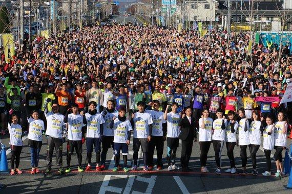 沢山のランナーと観客が正面を向いて笑っている集合写真