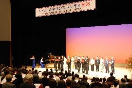 ステージの上でパープルシックスがコーラスを歌っているエイジ・ルネサンス・パーティの写真