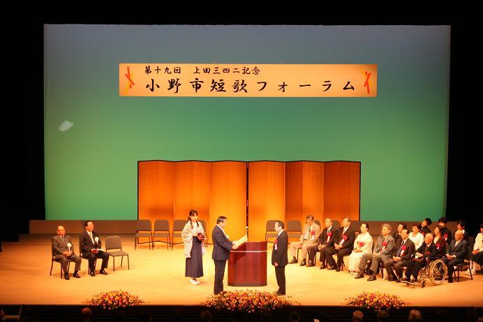 ステージの上で男性が表彰されている小野市短歌フォーラムの写真