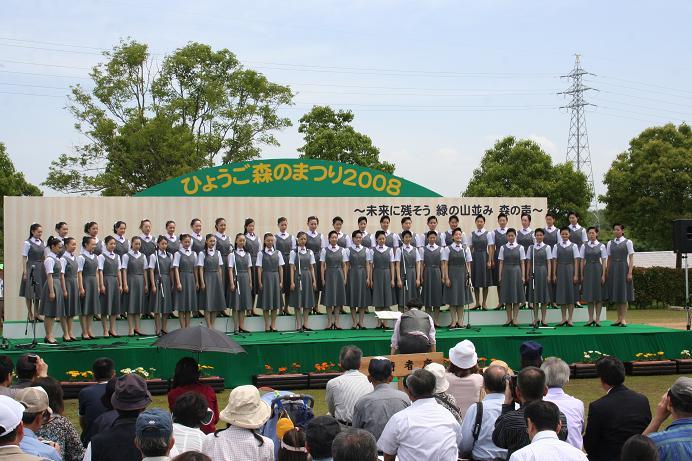 ステージの上で宝塚音楽学校の生徒たちがコーラスを歌っている写真