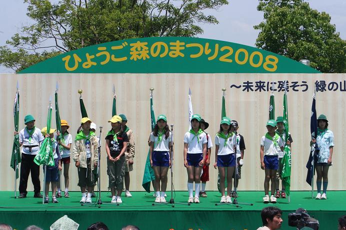 15名ほどの緑の少年団がステージの上に並んで立っている写真