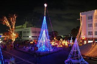 市役所前に飾られているクリスマスツリーや乗り物のオブジェなどのクリスマスイルミネーションの写真
