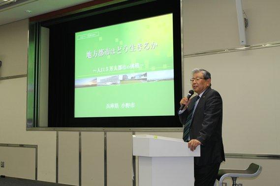 日経グローカルセミナー9月定例会でスクリーンを前に市長が発言している写真
