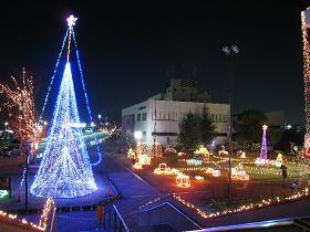 市役所前に飾られているクリスマスツリーや乗り物のオブジェなどのクリスマスイルミネーションの写真